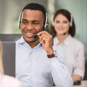 A customer service representative man with a smile on his face answering calls